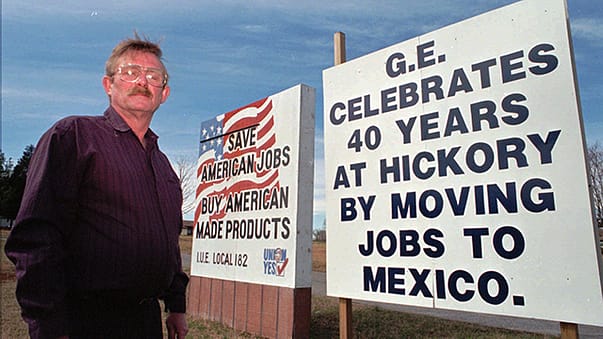 Gary Hefner, local union chapter 182 president, is seen Saturday, Feb. 22, 1997, standing in front of signs he put up after General Electric closed its plant in Hickory, NC, and moved it to Mexico. (AP Photo/Nell Redmond)