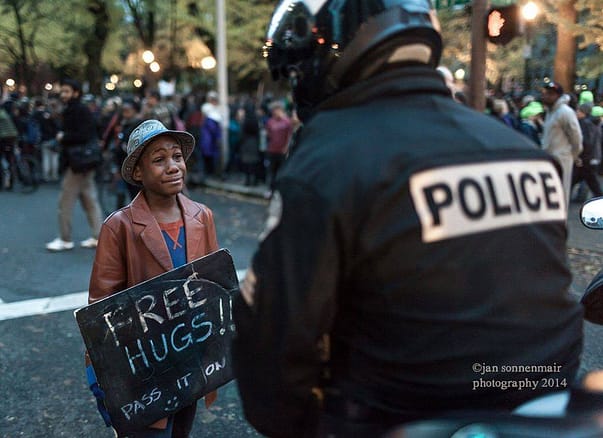 Police officer and young demonstrator share hug during Ferguson rally in Portland